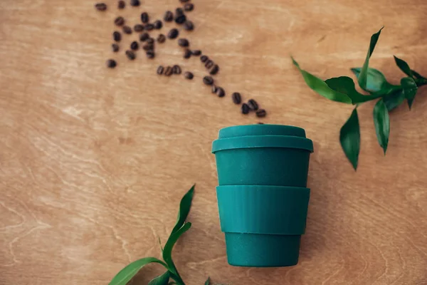 零浪费的概念 平坦的铺设 时尚可重复使用的生态咖啡杯在木制背景与咖啡豆和绿色竹叶 禁止一次性使用塑料 可持续发展的生活方式 天然竹杯 — 图库照片