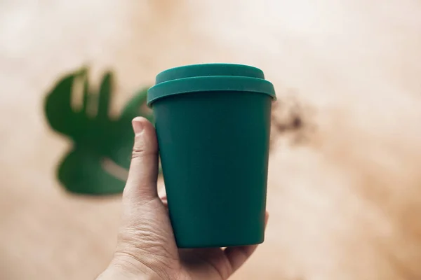 禁止一次性使用塑料 手拿生态可重复使用的咖啡杯在木制背景 咖啡杯从竹纤维 零浪费的概念 把咖啡放在杯子里 可持续发展的生活方式 — 图库照片