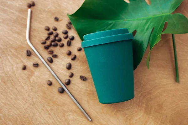 ゼロ廃棄物の概念 スタイリッシュな再利用可能なエコ コーヒー カップと緑のモンステラの葉と木製の背景に金属鋼のストロー 使い捨てプラスチックを禁止します 持続可能なライフ スタイル — ストック写真
