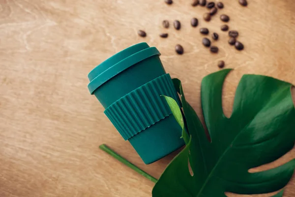 零浪费的概念 时尚可重复使用的生态咖啡杯在木制背景与烤咖啡豆和绿色的修道院叶 禁止一次性使用塑料 可持续发展的生活方式 天然竹杯 — 图库照片