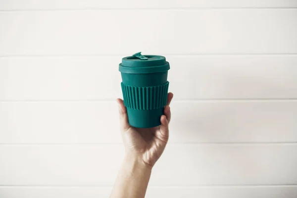 Hand Met Stijlvolle Herbruikbare Eco Coffee Cup Witte Houten Achtergrond — Stockfoto
