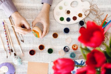 Üstten görünüm tutarak ve boya, fırça, lale buketi, metin için yer ile rustik tablo easter egg boyama el. Paskalya yumurtası, tatil hazırlıkları dekorasyon çocuk. Mutlu Paskalya kavramı