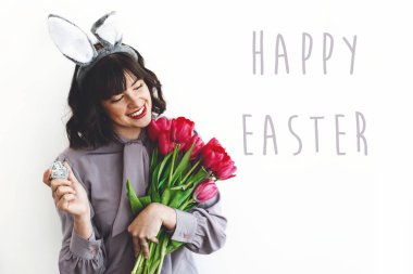 Mutlu paskalya metin işareti ve Paskalya yumurtası ve lale beyaz adam tutarak tavşan kulakları güzel mutlu kızı