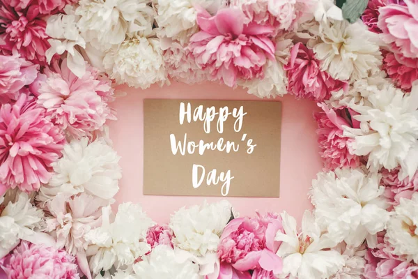 快乐的妇女节文字标志在空工艺卡上的牡丹框架平躺在粉红色的柔和纸 — 图库照片
