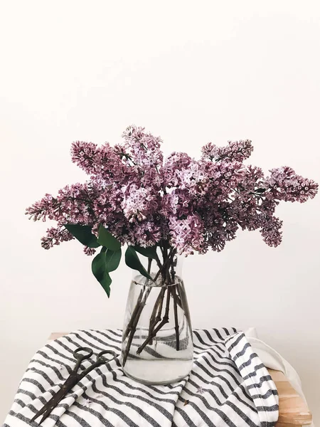 时尚的淡紫色花束在玻璃花瓶在质朴的木梯与织物在房间里 春天的丁香花在椅子上花束 乡村依然鲜活 母亲节快乐 — 图库照片