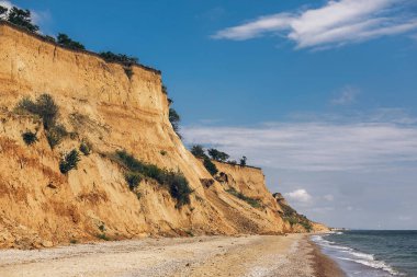 Kumlu cliff deniz beach yakınındaki güzel manzarasına. Manzara plaj cliff ve güneşli havalarda dalgalar. Yaz tatil kavramı. İlginç yerler keşfetmek