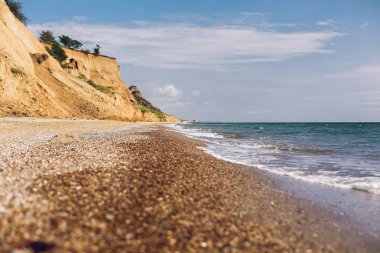 Kumlu cliff deniz beach yakınındaki güzel manzarasına. Manzara plaj cliff ve güneşli havalarda dalgalar. Yaz tatil kavramı. İlginç yerler keşfetmek
