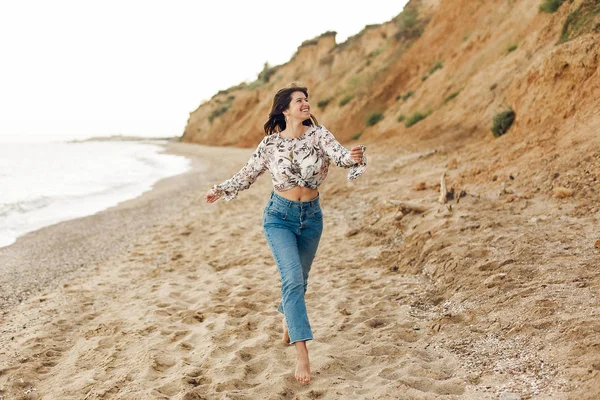 Çalışan ve rock ile güneşli plajda eğlenerek mutlu genç boho kadın. Rahatlatıcı ve denizde gülümseyen hipster ince kız. Yaz tatil kavramı. Uzay kopyalayın. Neşeli an