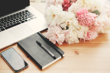 Boş ekran, laptop, defter, kalem, pembe ile şık telefon bir