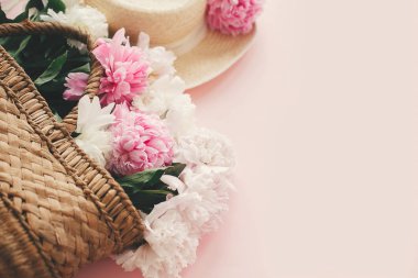 Şık hasır rustik sepeti ve pembe ve beyaz peonies ile şapka
