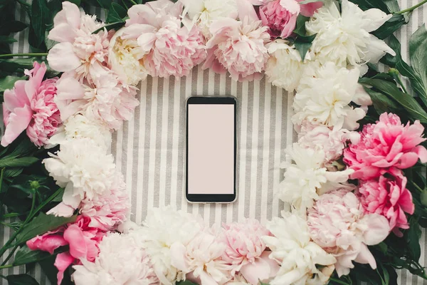테이블에 분홍색과 흰색 모란 프레임에 빈 화면으로 전화 — 스톡 사진