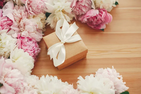 Schöne Geschenkschachtel mit Band in rosa und weißen Pfingstrosen Rahmen o — Stockfoto
