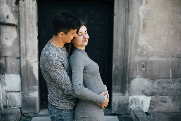 Стильная беременная пара, держащаяся за руки на шишке и расслабляющая — стоковое фото