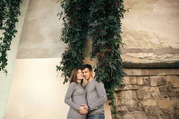 Stylish pregnant couple holding hands on baby bump and relaxing — Stock Photo, Image