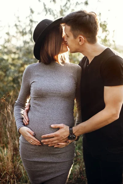 Happy young parents, mom and dad, abraçando baby bump, beijando, en — Fotografia de Stock