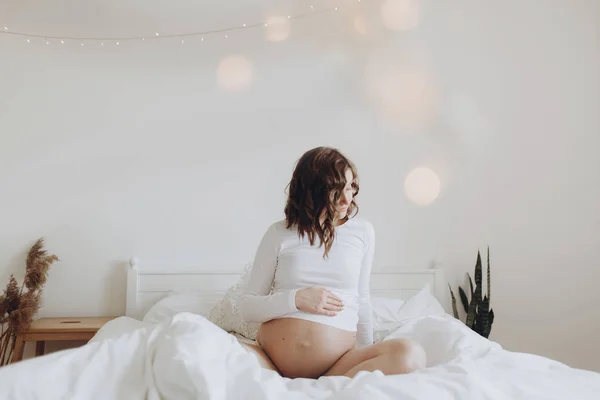 Stijlvolle zwangere moeder knuffelen buik met liefde en zorg, wachten f — Stockfoto