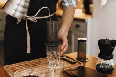 Holding çelik su ısıtıcısı ve aeropress, cam fincan, ölçekler, gri eller