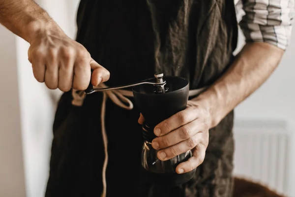 Barista professionnel en noir tablier élégant broyage café pour — Photo