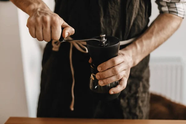 Barista profesional en negro elegante delantal moliendo café para — Foto de Stock