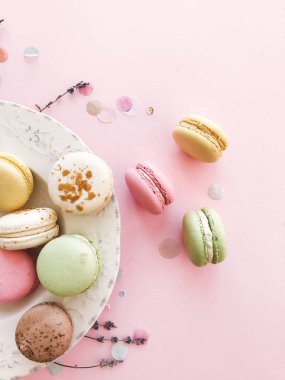 Lezzetli pembe ve yeşil macaroons pembe kağıt, düz üzerinde yatıyordu. Colo