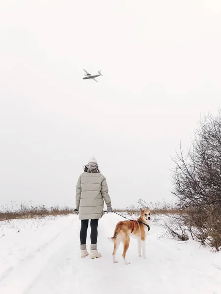 Стильная хипстерша гуляет с милой золотой собакой на снежном холоде. — стоковое фото