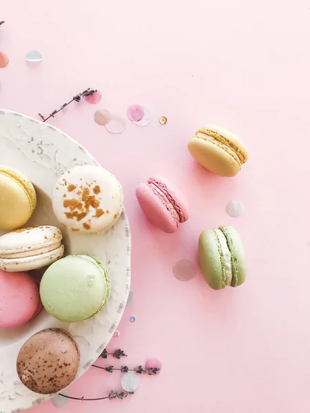 Delicious pink and green macaroons on pink paper, flat lay. Colo — Stock Photo, Image