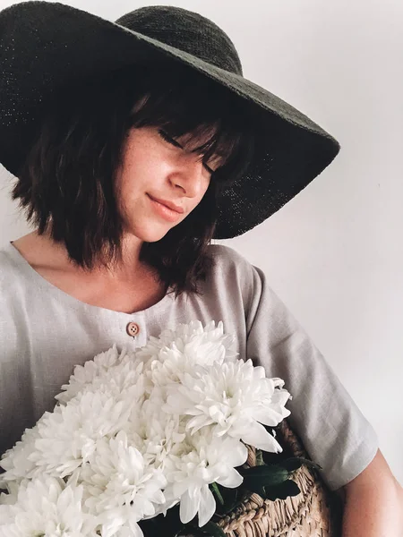 Hermosa chica en vestido de lino y sombrero que sostiene la cesta de paja con — Foto de Stock