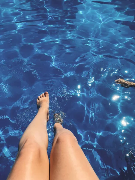 Nyári pihenés és lazítson. Lány cserzett lábát a medence kék — Stock Fotó