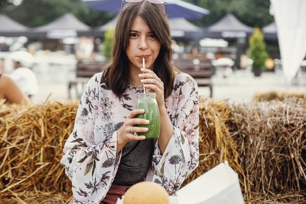 Stilig hipster boho jente drikker smoothie i glass krukke med de – stockfoto