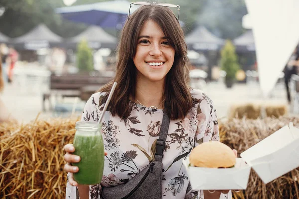 Elegante chica hipster en gafas de sol con deliciosa hamburguesa vegana —  Fotos de Stock