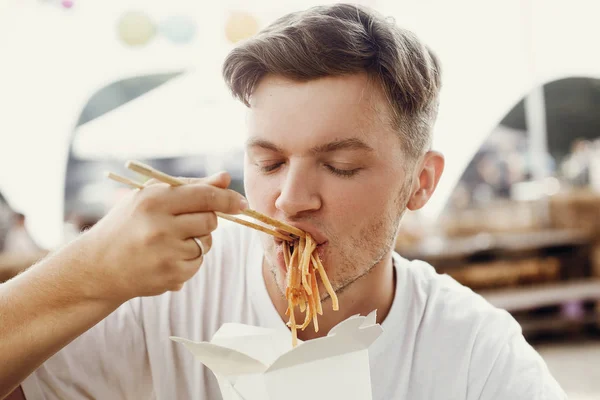 Elegante hombre hipster comiendo deliciosos fideos wok con verduras — Foto de Stock