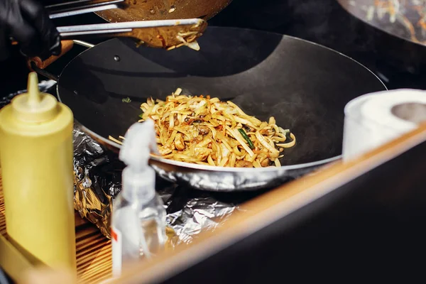 Festival de comida callejera asiática en la ciudad. Fideos y verduras de cocina de chef —  Fotos de Stock