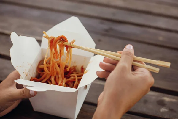 Wok with noodles and vegetables in carton box to go and bamboo c — Stock Photo, Image