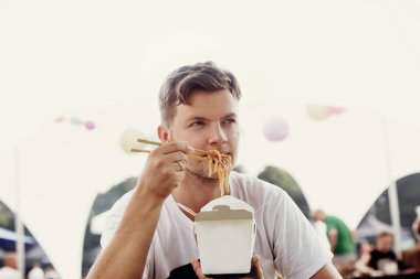 Şık hipster man yemek wok noodles sebze sepeti