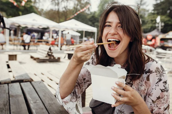Hungry boho woman eating noodles in takeaway paper box. Food del — Stock Photo, Image