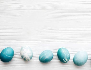 Şık Paskalya yumurtaları düz spa ile beyaz ahşap zemin üzerinde yatıyordu