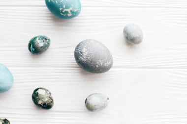 Şık Paskalya yumurtaları düz spa ile beyaz ahşap zemin üzerinde yatıyordu