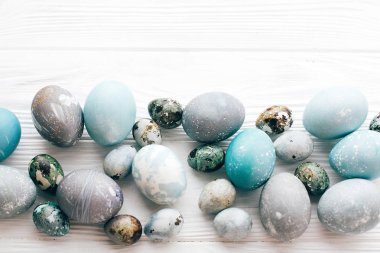 Şık Paskalya yumurta düz kenarlık w Beyaz ahşap zemin üzerinde yatıyordu