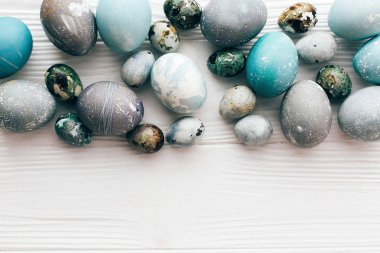 Şık Paskalya yumurtaları düz spa ile beyaz ahşap zemin üzerinde yatıyordu