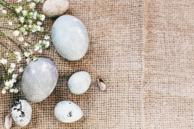 Sunn rustik kumaş üzerinde bahar çiçekleri ile şık Paskalya yumurtaları