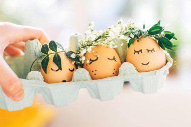 Çiçek çelenk kron c şirin yüzleri ile şık Paskalya yumurtaları