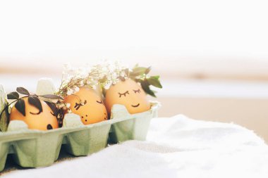 Mutlu paskalyalar. Çiçek wrea şirin yüzleri ile şık Paskalya yumurtaları