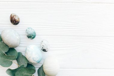 Beyaz ahşap backg dalda okaliptüs ile şık Paskalya yumurtaları