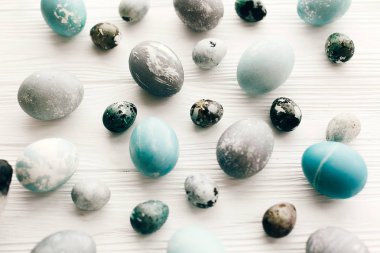 Şık Paskalya yumurtaları düz beyaz ahşap zemin üzerinde yatıyordu. Modern 