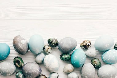 Şık Paskalya yumurtaları düz spa ile beyaz ahşap zemin üzerinde yatıyordu