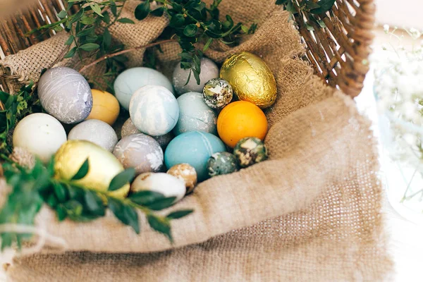 Eleganti uova di Pasqua e rami di buxus verde in cesto di vimini su — Foto Stock