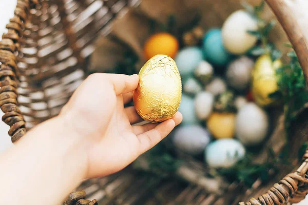 Concepto de caza de Pascua. Mano sosteniendo huevo de Pascua de oro y elegante — Foto de Stock