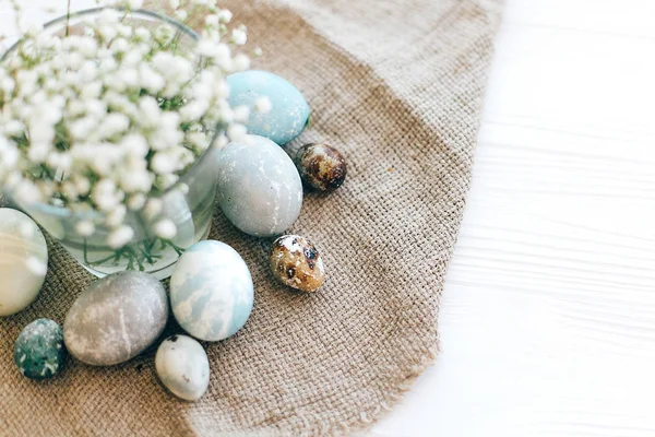 Стильні великодні яйця на сільській тканині з весняними квітами на — стокове фото