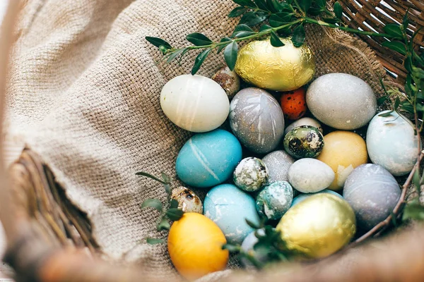 Elegantes huevos de Pascua y ramas de buxus verde en mimbre rústico ba — Foto de Stock