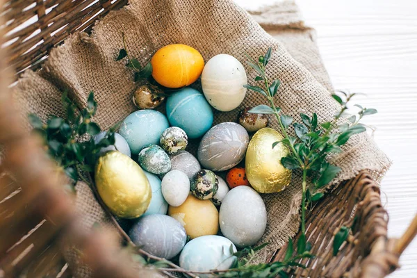 Elegantes huevos de Pascua y ramas de buxus verde en mimbre rústico ba — Foto de Stock